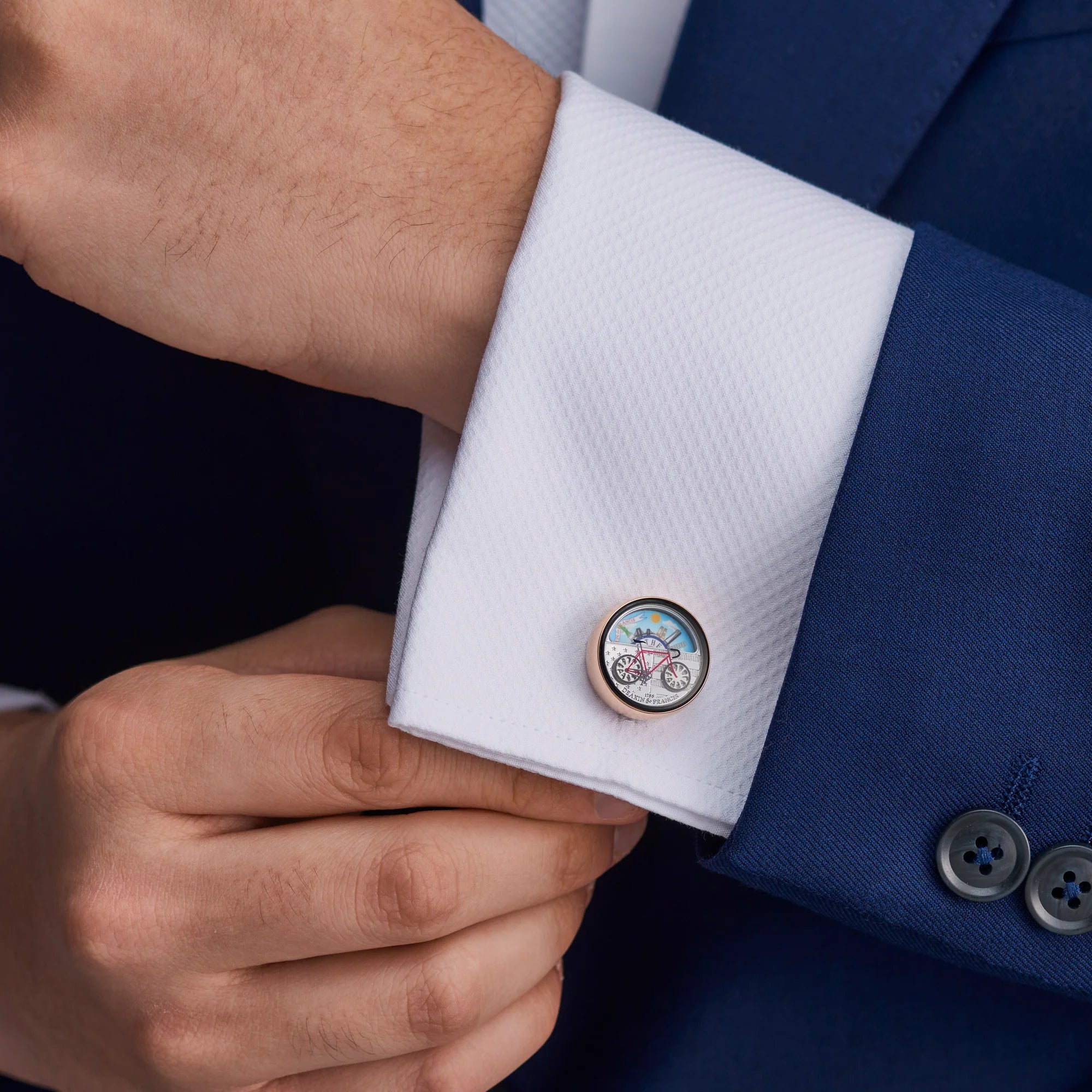 New York moving scene cufflinks on coat with spinning bicycle wheels and city backdrop by Deakin & Francis at EB London