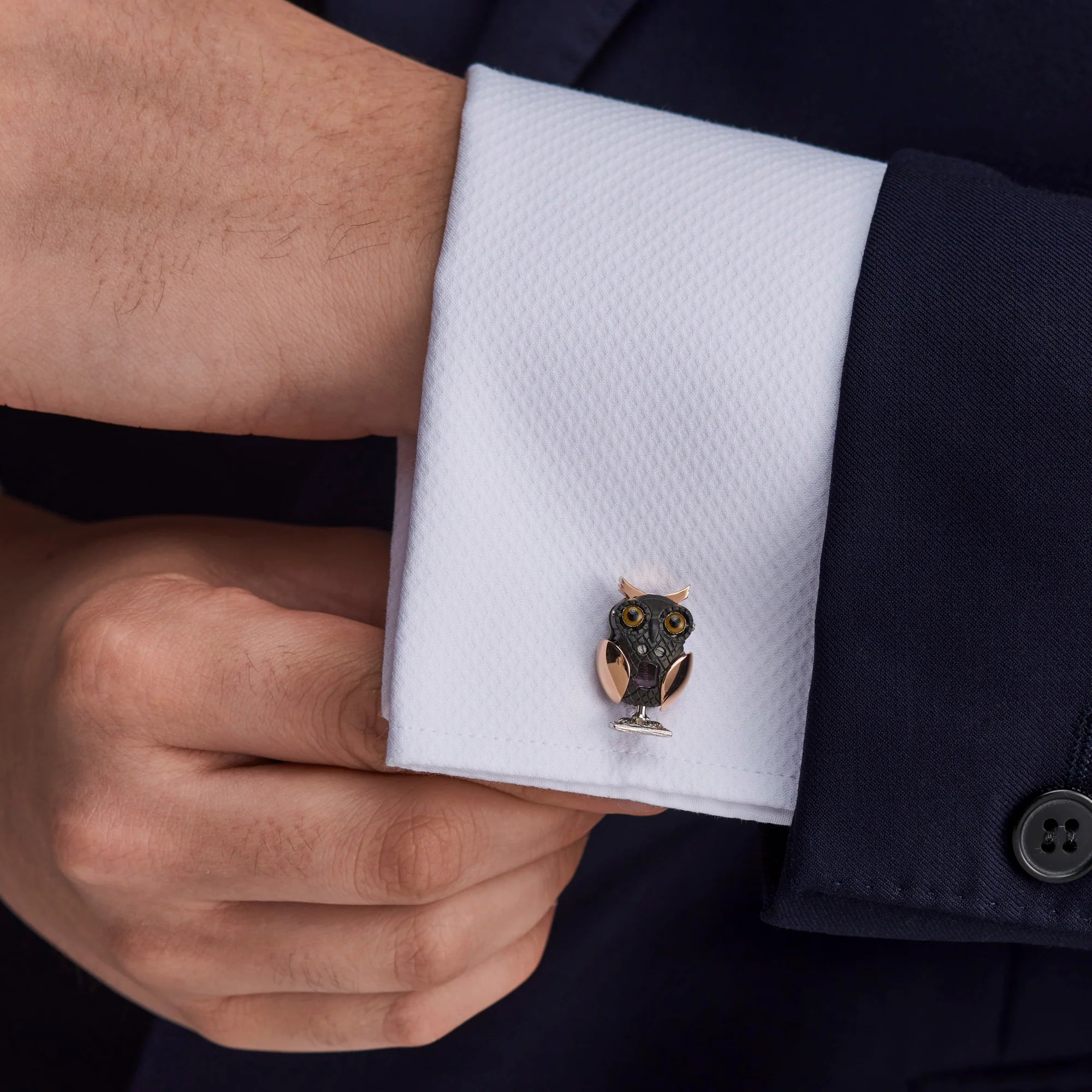 Cufflink with owl design on a white cuff against a navy suit - EB London