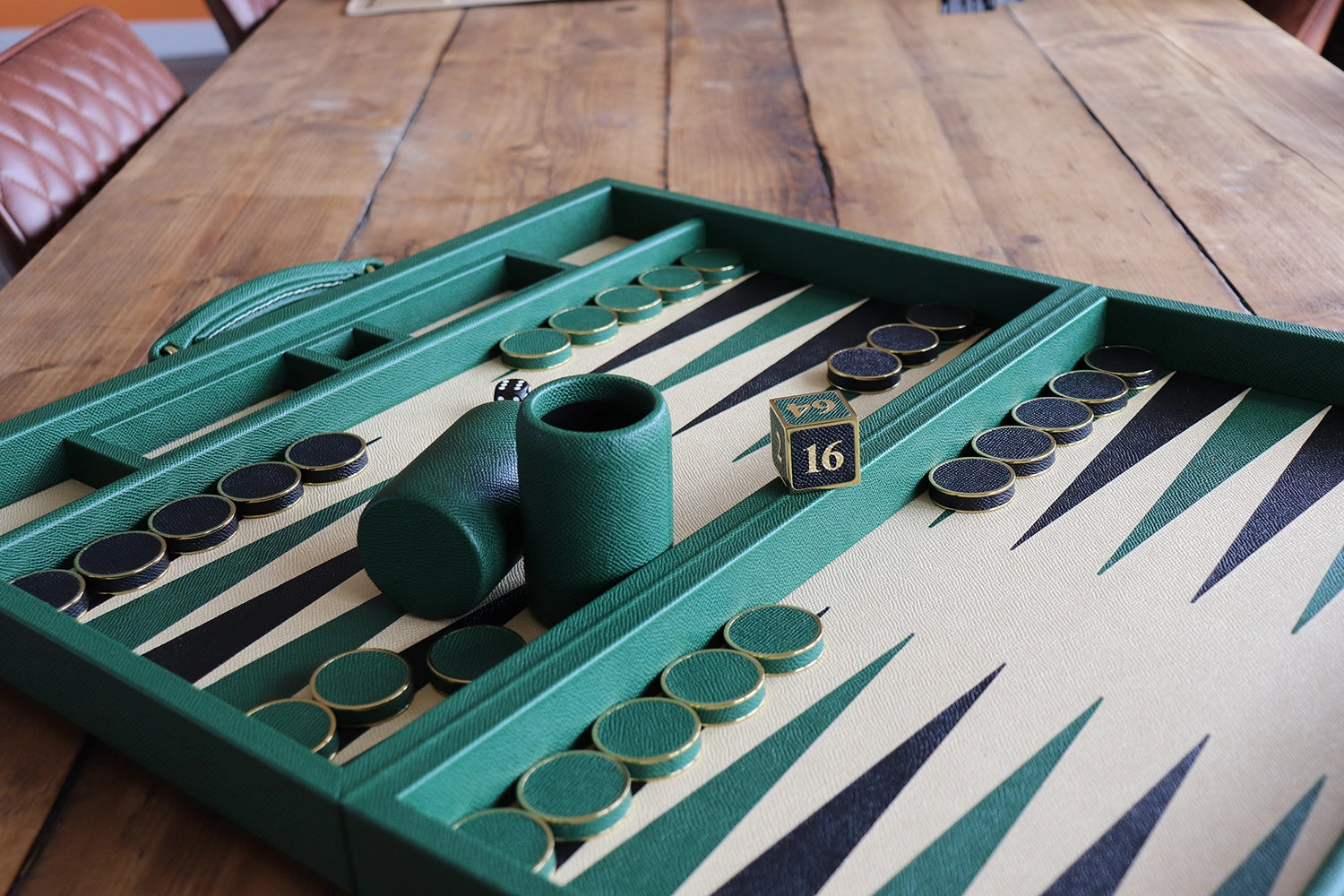 Conifer green tournament backgammon set with magnolia playing surface, leather and metal stones, and luxury dice cups handcrafted in England by Geoffrey Parker.