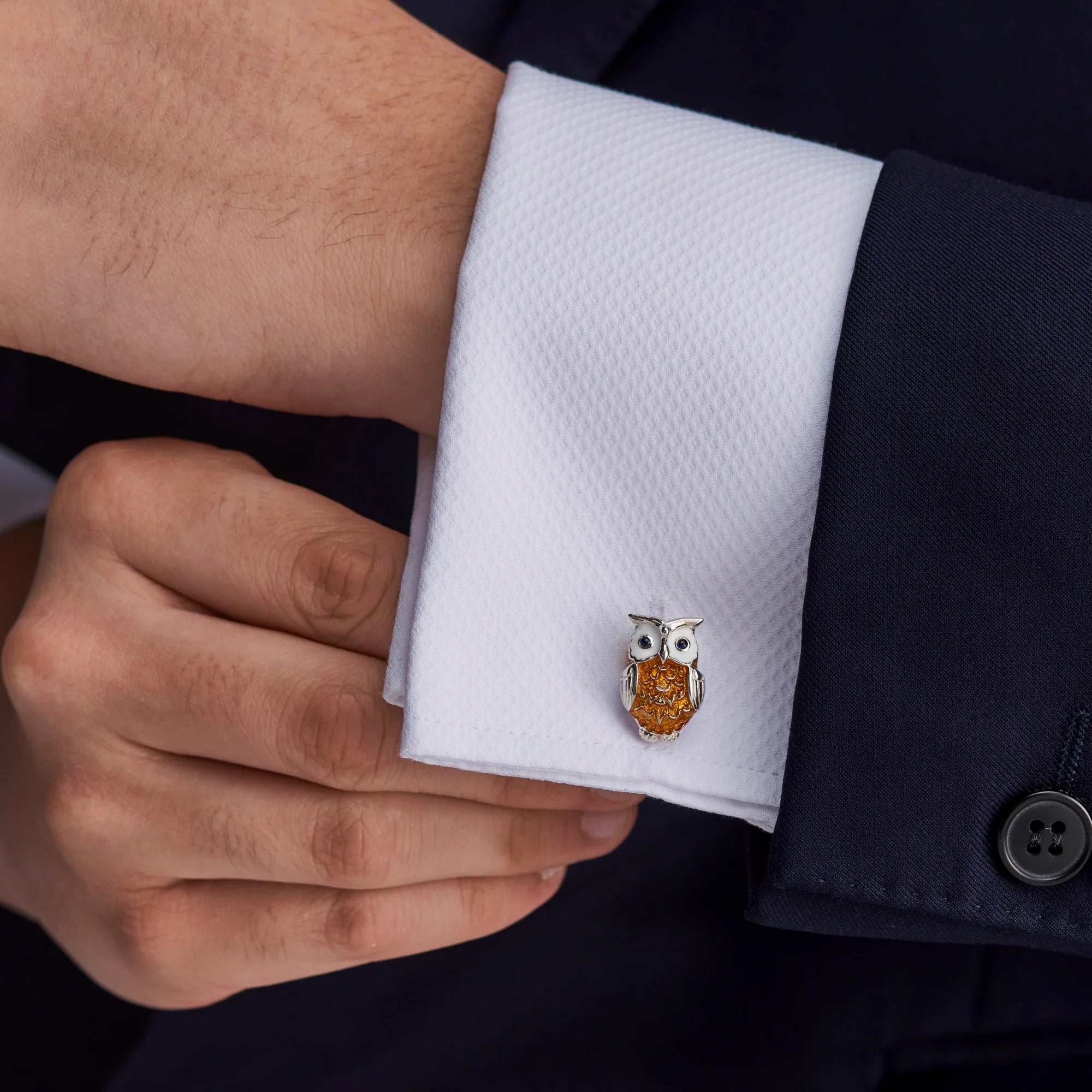 Cufflink with owl design on a white cuff against a dark suit background - EB London