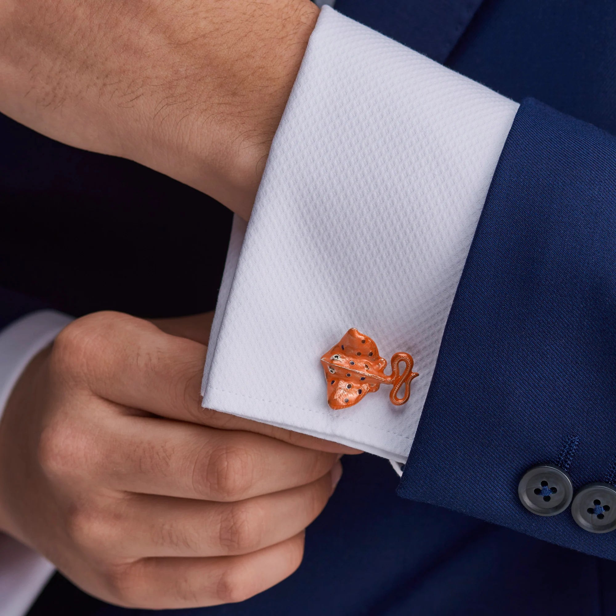 Cufflink on a white cuff against a blue suit background - EB London